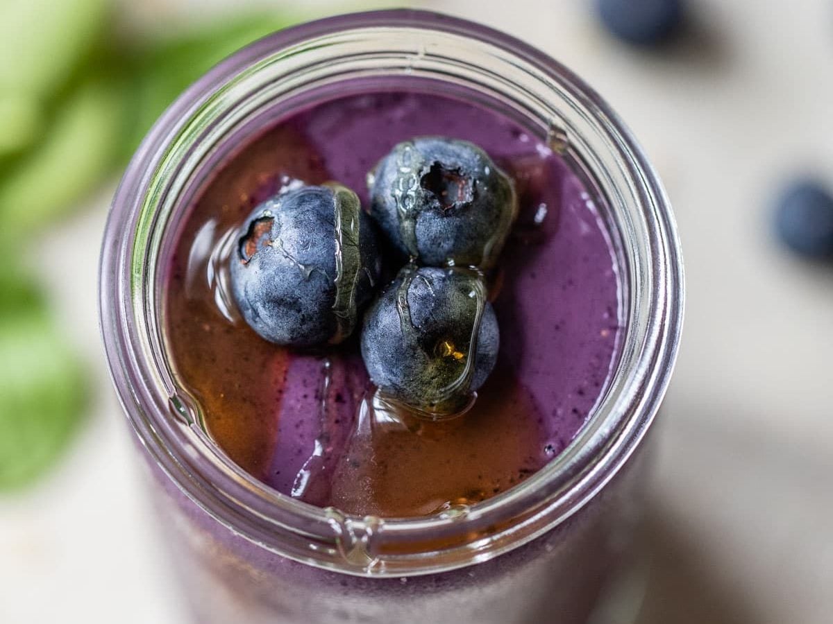A healthy blueberry spinach smoothie in a mason jar