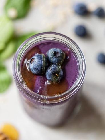 A healthy blueberry spinach smoothie in a mason jar