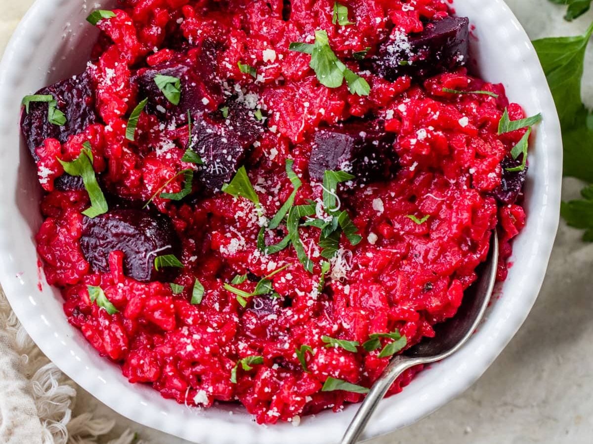 A bowl of vegetarian beet risotto with a spoon