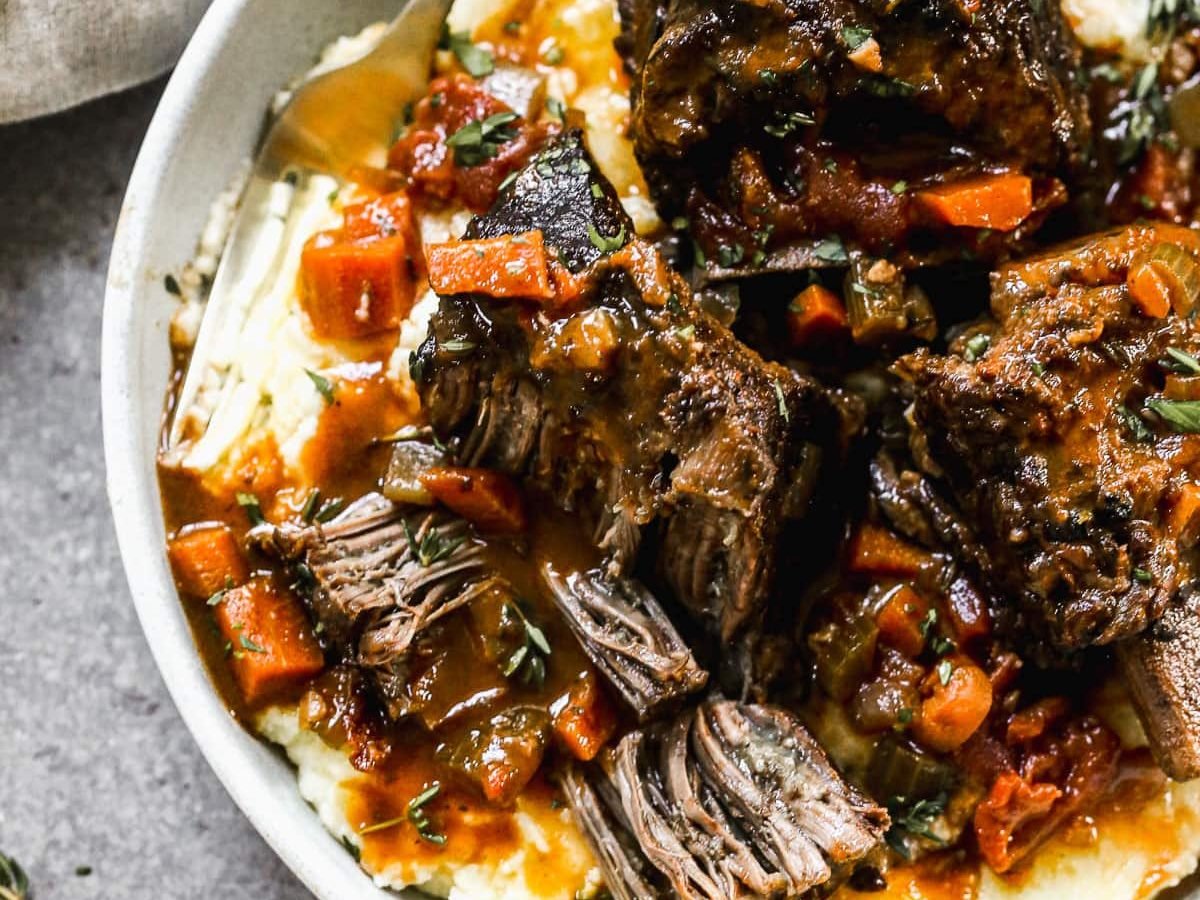 Red wine braised short rib pasta with mashed potatoes in a gray bowl