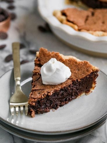 a slice of fudge brownie pie topped with whipped cream
