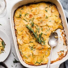 Best Scalloped Potatoes recipe in a casserole dish and on plates