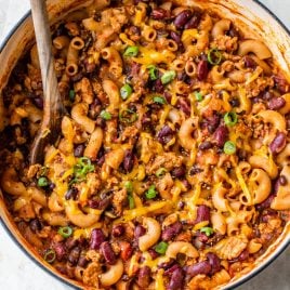 Healthy Chili Mac and Cheese recipe in a white dutch oven topped with green onions