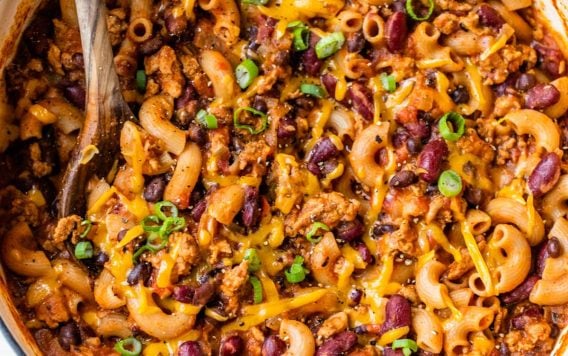 Healthy Chili Mac and Cheese recipe in a white dutch oven topped with green onions