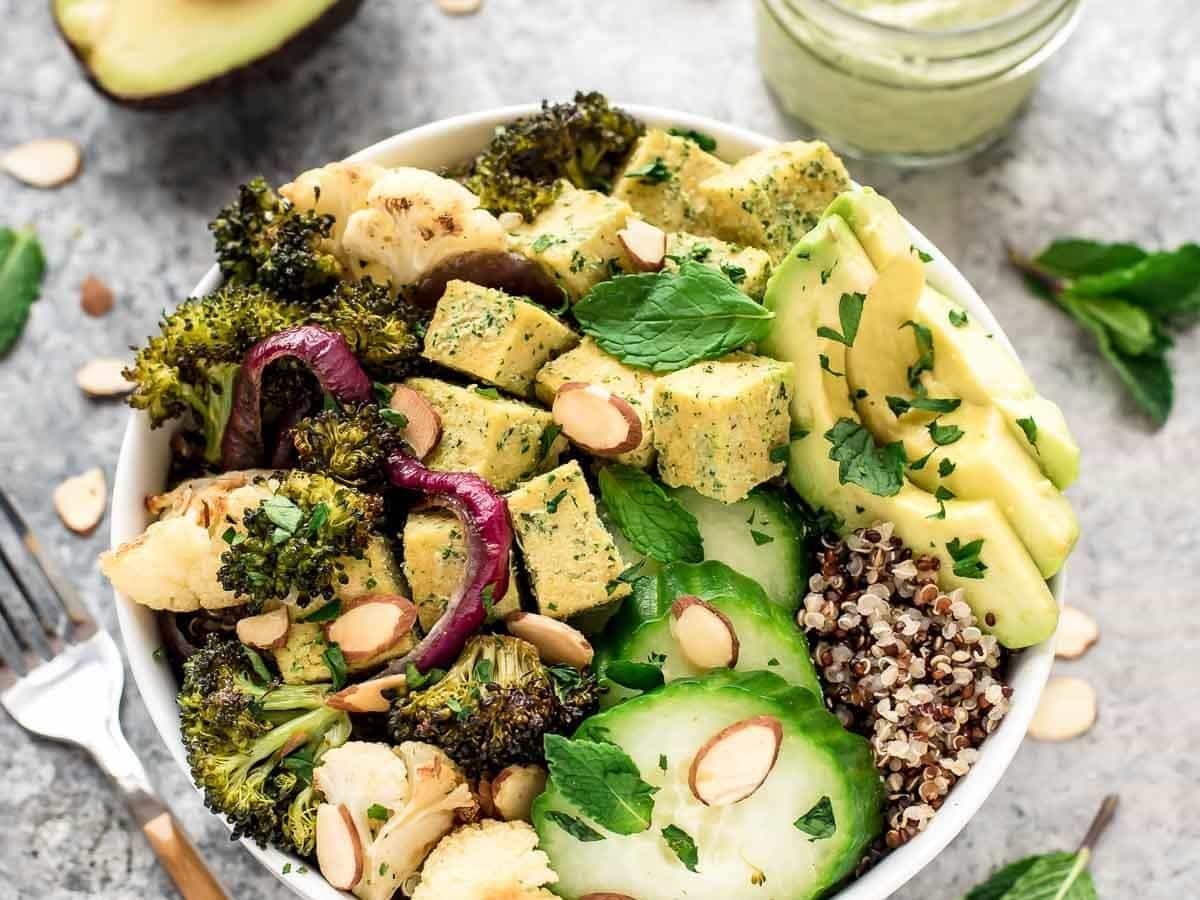 a roasted veggie buddha bowl with tahini dressing, tofu and quinoa