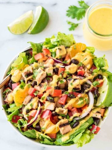 Grilled Caribbean Chicken Salad with 5 Minute Mango Dressing. WAY better than your favorite restaurant salad at a fraction of the cost! Packed with juicy chicken, crunchy veggies, black beans, and the best tangy mango dressing! @wellplated