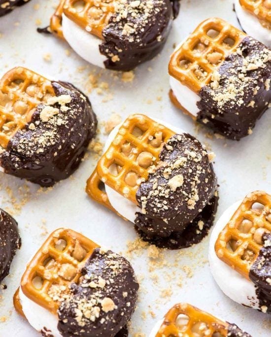 Easy Chocolate Dipped Pretzel Smores—a marshmallow peanut butter pretzel “sandwich” dipped in chocolate with graham cracker crumbs. EASY recipe that's fun to make with kids or bring to a party. @wellplated