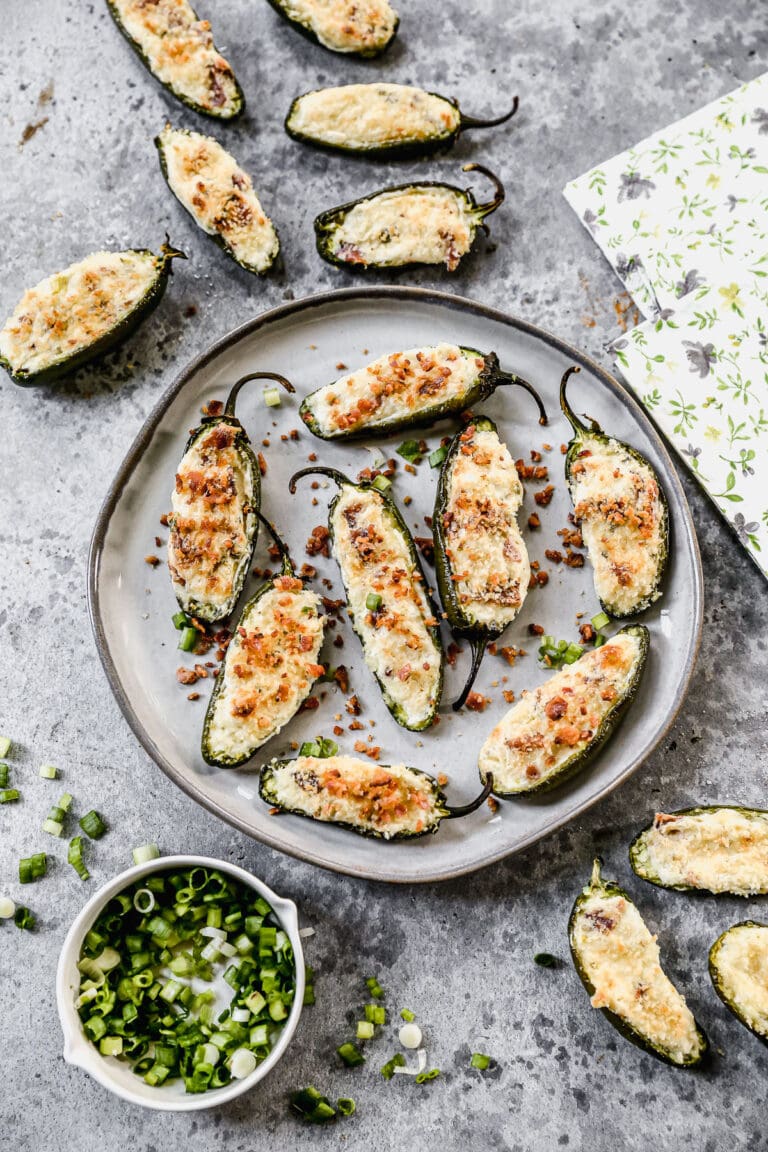 Bacon Jalapeno Poppers on a plate with green onions