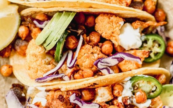 Crispy Cauliflower Tacos with chickpeas topped with avocado, jalapeno, and red cabbage