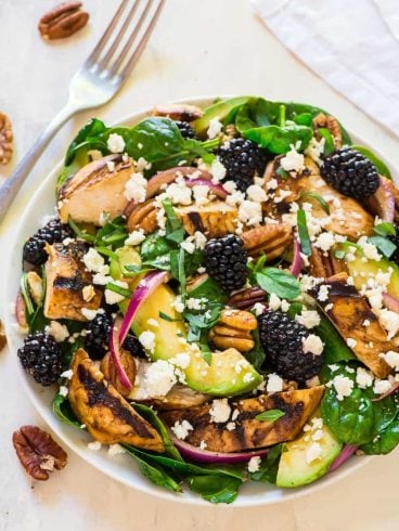 A bowl of balsamic chicken salad with blackberries and avocado