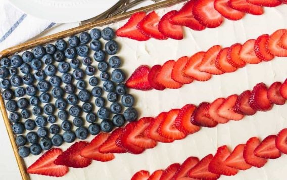 American Flag Cake. Made with REAL ingredients! From scratch fluffy yellow sheet cake, topped with Greek yogurt cream cheese frosting, fresh strawberry, and blueberry to look like an American flag. The perfect patriotic dessert recipe for the Fourth of July, Memorial Day, and Labor Day. Recipe at wellplated.com | @wellplated