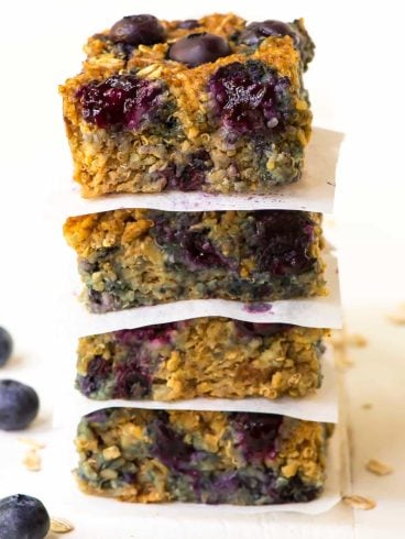 A stack of quinoa breakfast bars with blueberries