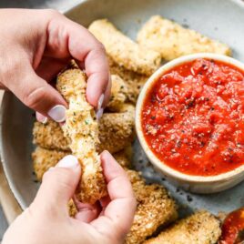 gooey mozzarella stick with string cheeses being pulled apart