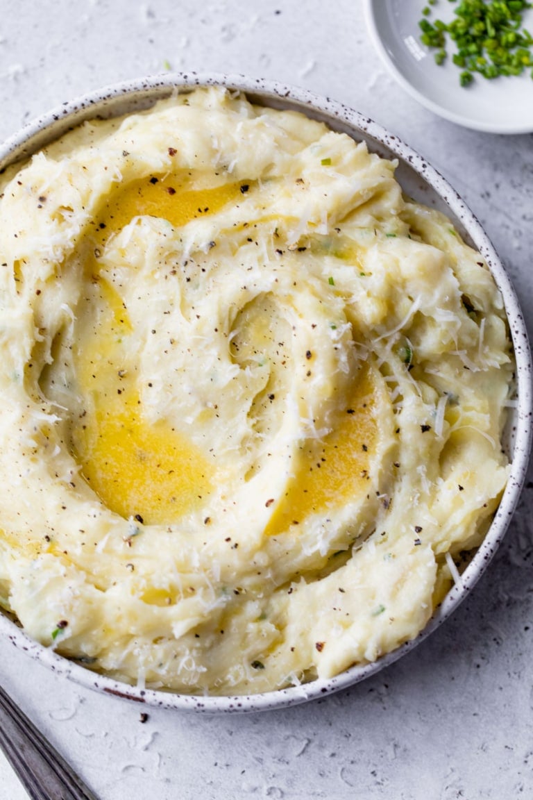 The BEST instant pot mashed potatoes in bowl with melted butter and cheese