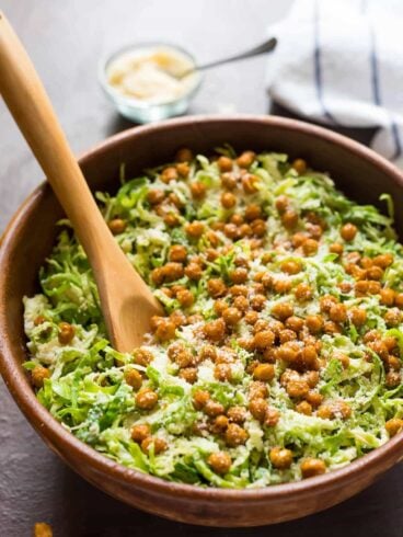 Caesar Shaved Brussel Sprout Salad with Roasted Chickpea Croutons. Perfect for healthy lunches or a holiday side dish. Made with shredded brussels sprouts, crispy roasted chickpeas, and creamy Caesar dressing. Easy and low carb!