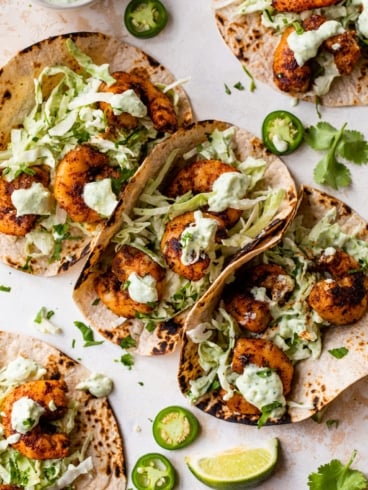 The BEST Healthy Shrimp Tacos with Cilantro Lime Sauce and Cabbage Slaw. Juicy, spicy, and so quick and easy! Cook on the stove or grill!