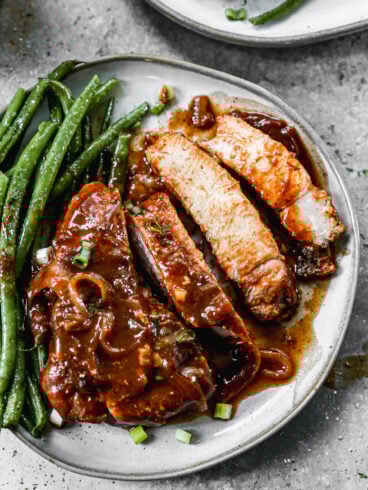 sliced juicy crockpot pork chops on a plate