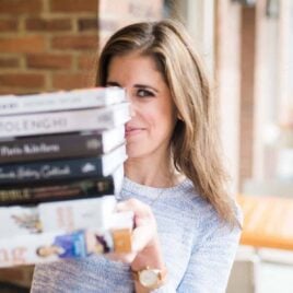 Erin Clarke holding a stack of cookbooks