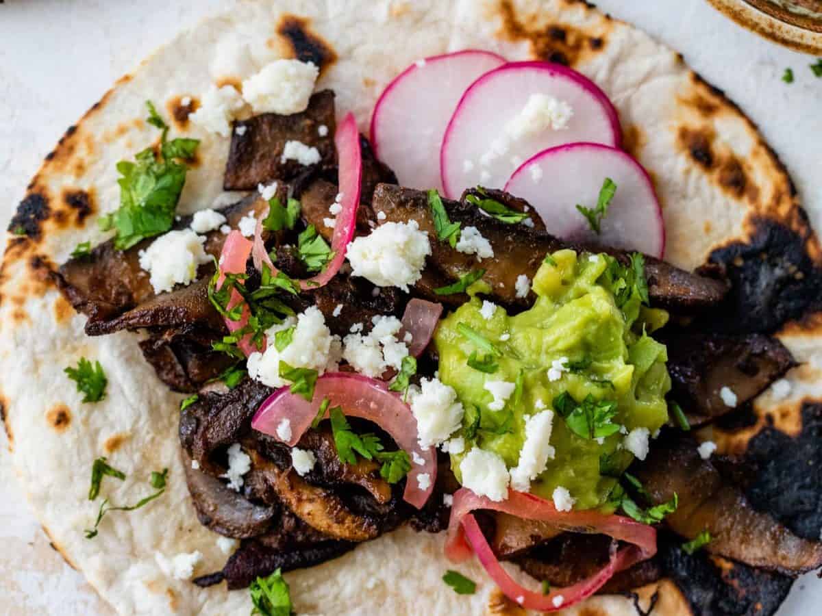 Overhead view of mushroom tacos with portobellos and toppings