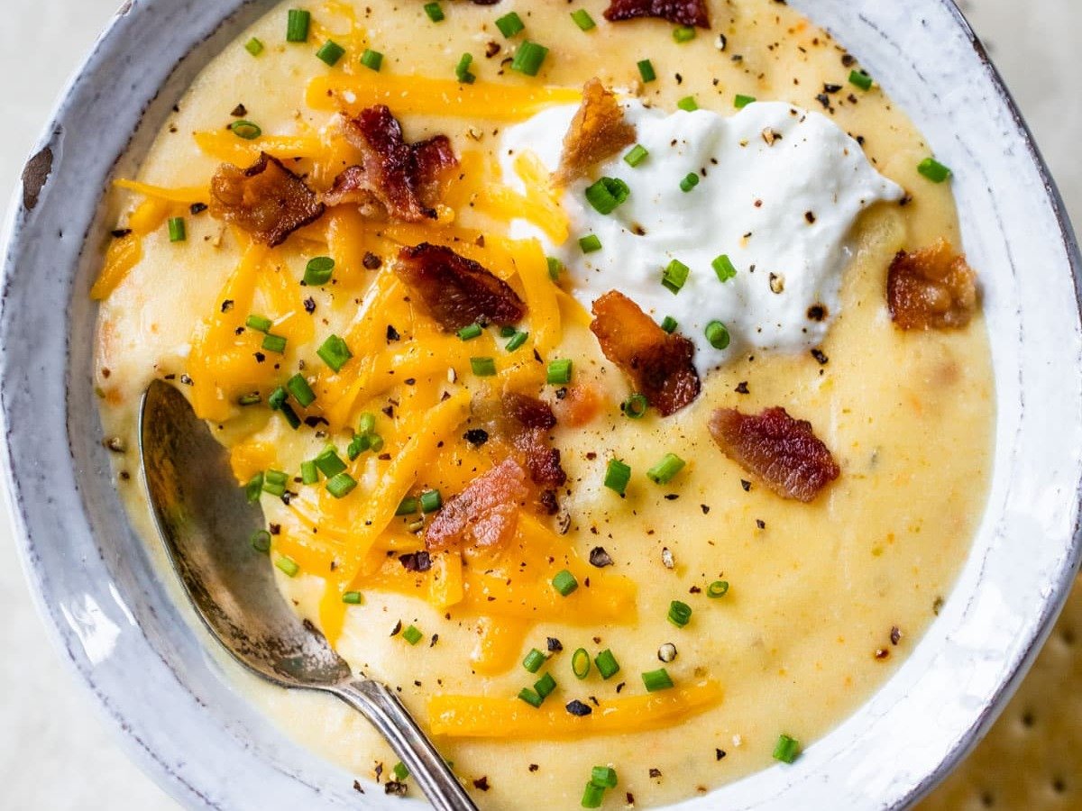 a bowl of cheesy crockpot potato soup from scratch with a spoon