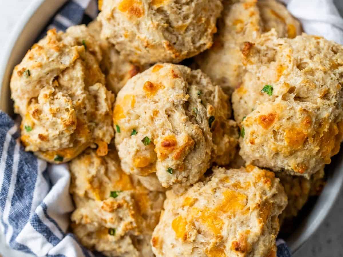 Fluffy drop style biscuits in a bowl with a dish towel