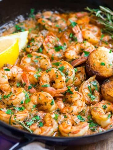 A Skillet of Healthy Garlic Butter Shrimp with Lemon Slices and Rosemary