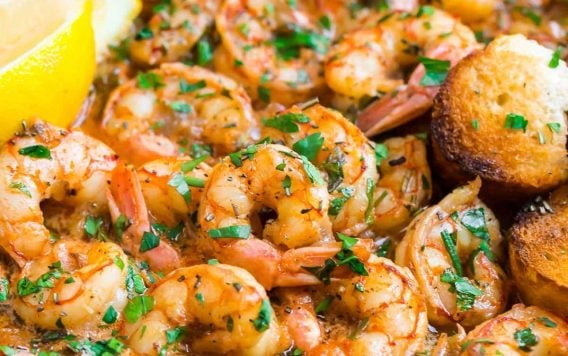 A Skillet of Healthy Garlic Butter Shrimp with Lemon Slices and Rosemary