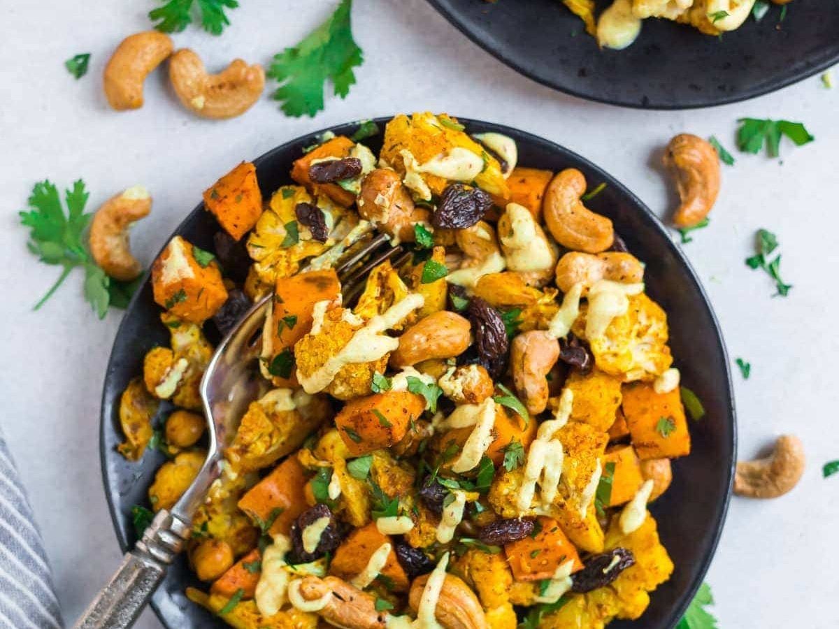 Two black plates with curry roasted cauliflower salad