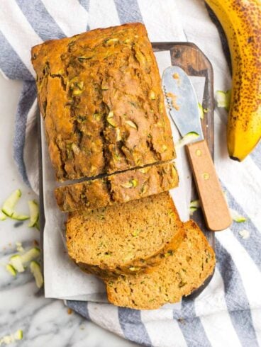 A loaf of moist zucchini banana bread with slices cut