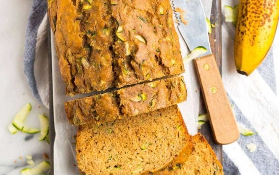 A loaf of moist zucchini banana bread with slices cut