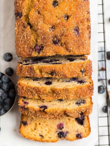A loaf of blueberry bread on a baking rack