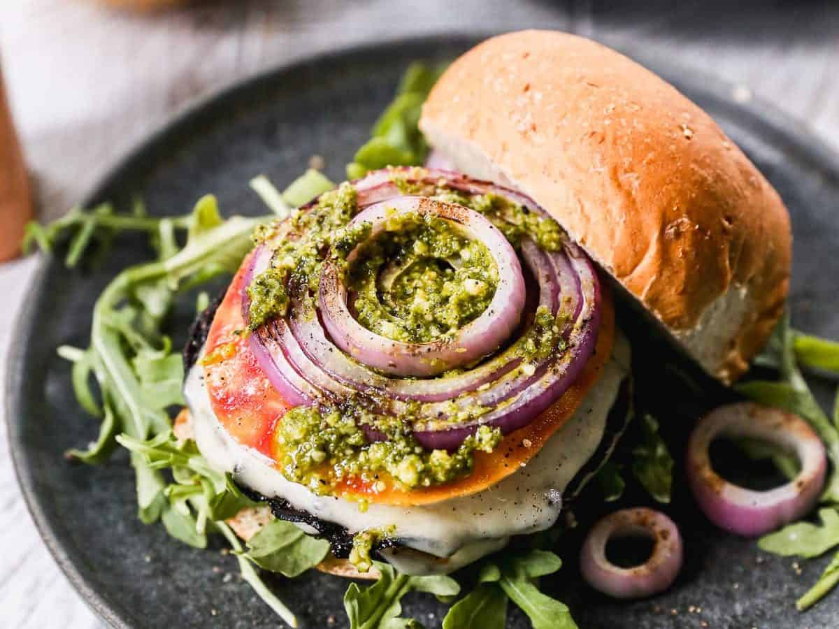 Grilled vegetarian portobello mushroom burger on plate with toppings