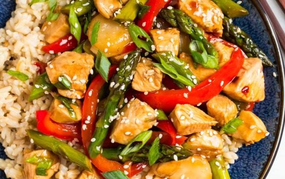 Teriyaki chicken stir fry and rice on a blue plate