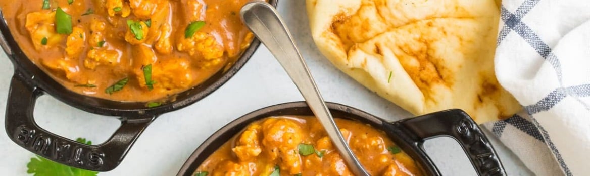 slow cooker butter chicken in black bowls