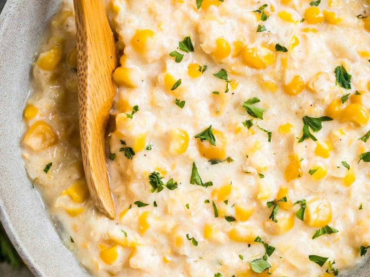 Crock Pot Creamed Corn in a bowl with a spoon, served as a easy slow cooker side dish