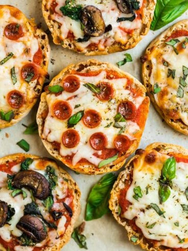 An assortment of english muffin pizzas with toppings