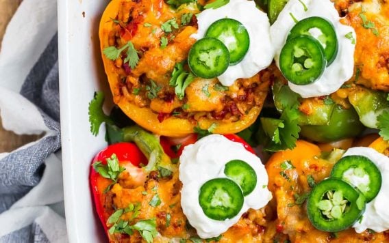 Easy and Tasty Mexican Stuffed Peppers filled with chicken, rice, and cheese, topped with Greek yogurt and jalapenos