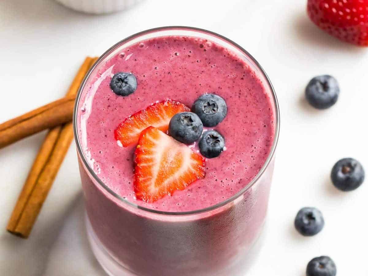 A healthy strawberry blueberry smoothie made with good for you strawberries and blueberries, almond milk, and yogurt, poured in a glass