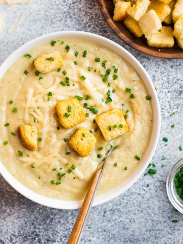 A white bowl with Instant Pot potato soup and croutons