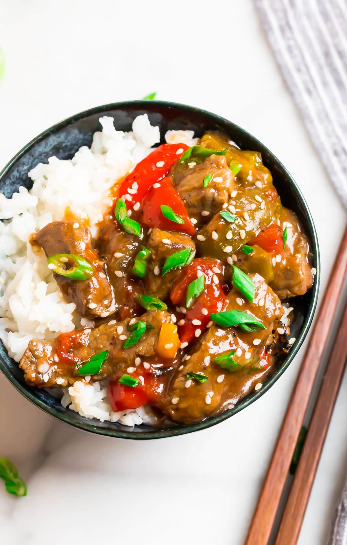 A bowl of crock pot pepper steak with peppers and white rice