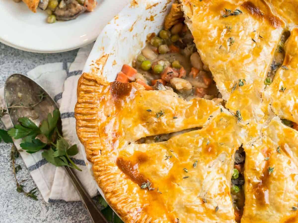 A vegetarian pot pie made with white beans and mushrooms and vegetables in a white pie dish