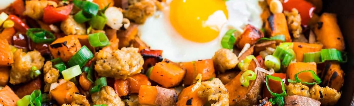 eggs baked on top of sweet potato hash with sausage and red bell peppers