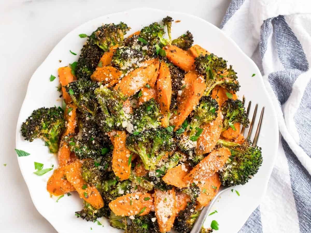 Roasted broccoli and carrots on a plate with Parmesan