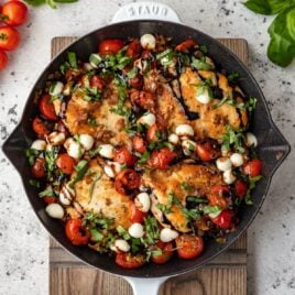 A white skillet with Caprese Chicken