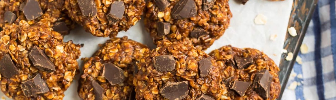 healthy no bake cookies on parchment paper topped with pieces of chocolate