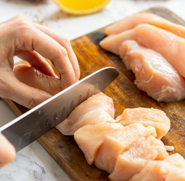 Chicken being sliced on a cutting board