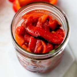 Top-down view of homemade roasted red peppers in jar