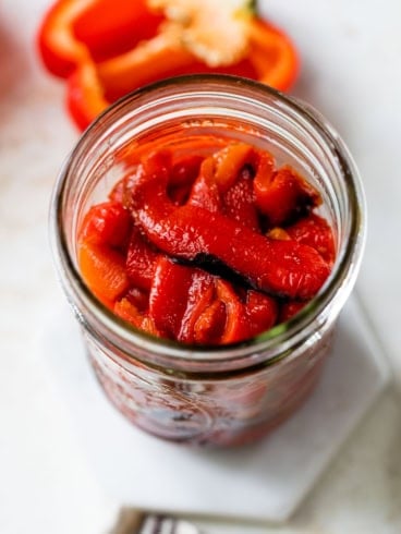 Top-down view of homemade roasted red peppers in jar