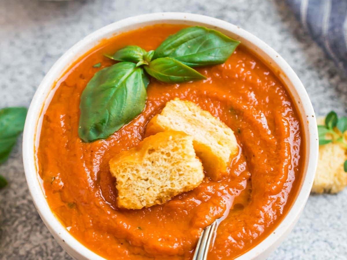 A bowl of Instant Pot tomato soup with croutons and basil
