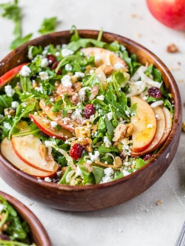 A bowl of apple walnut salad with arugula
